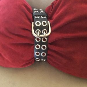 Leather belt with accentuating grommets.